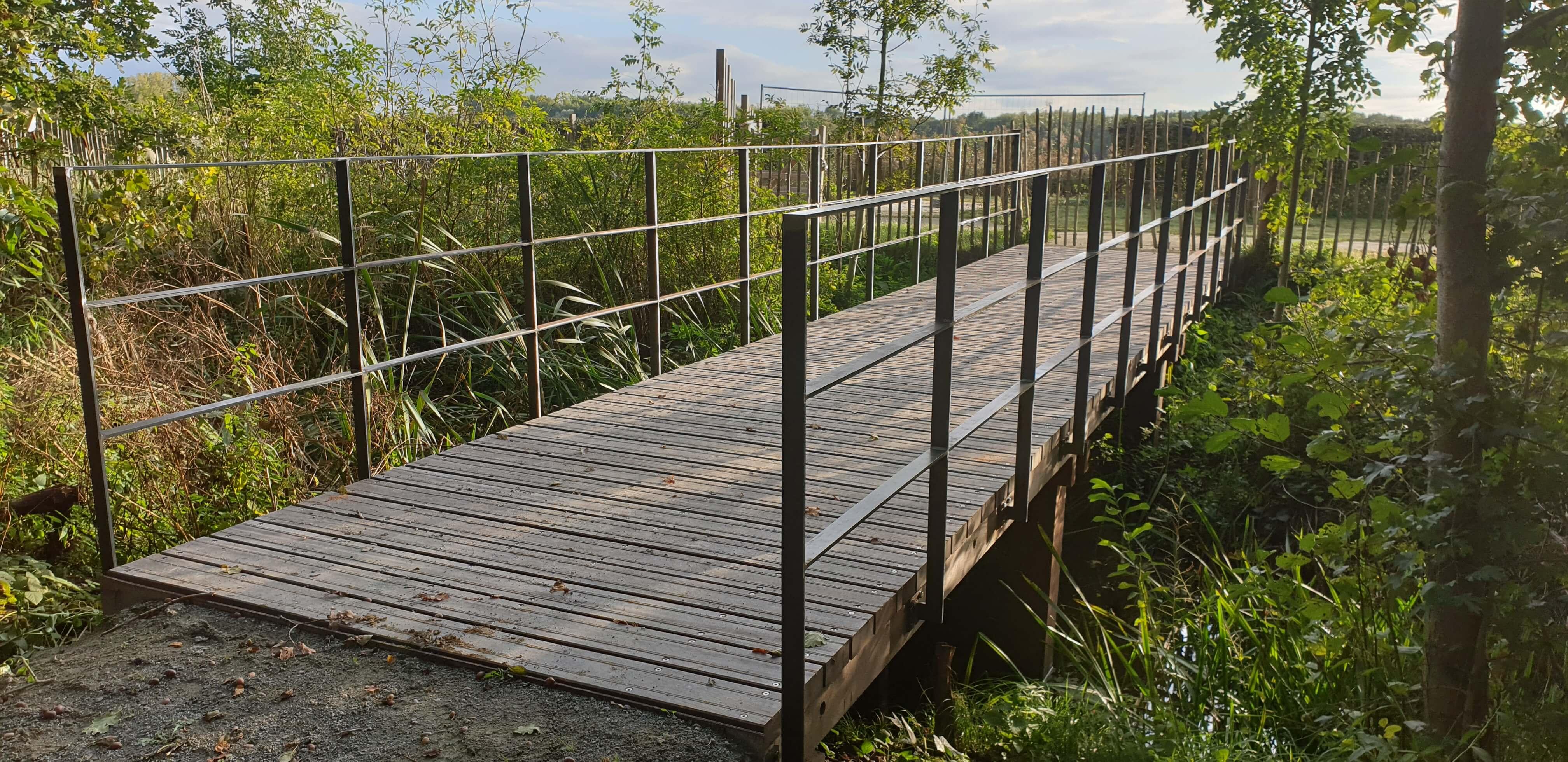 rechte houten brug van Woodrow in het groen te Berlare