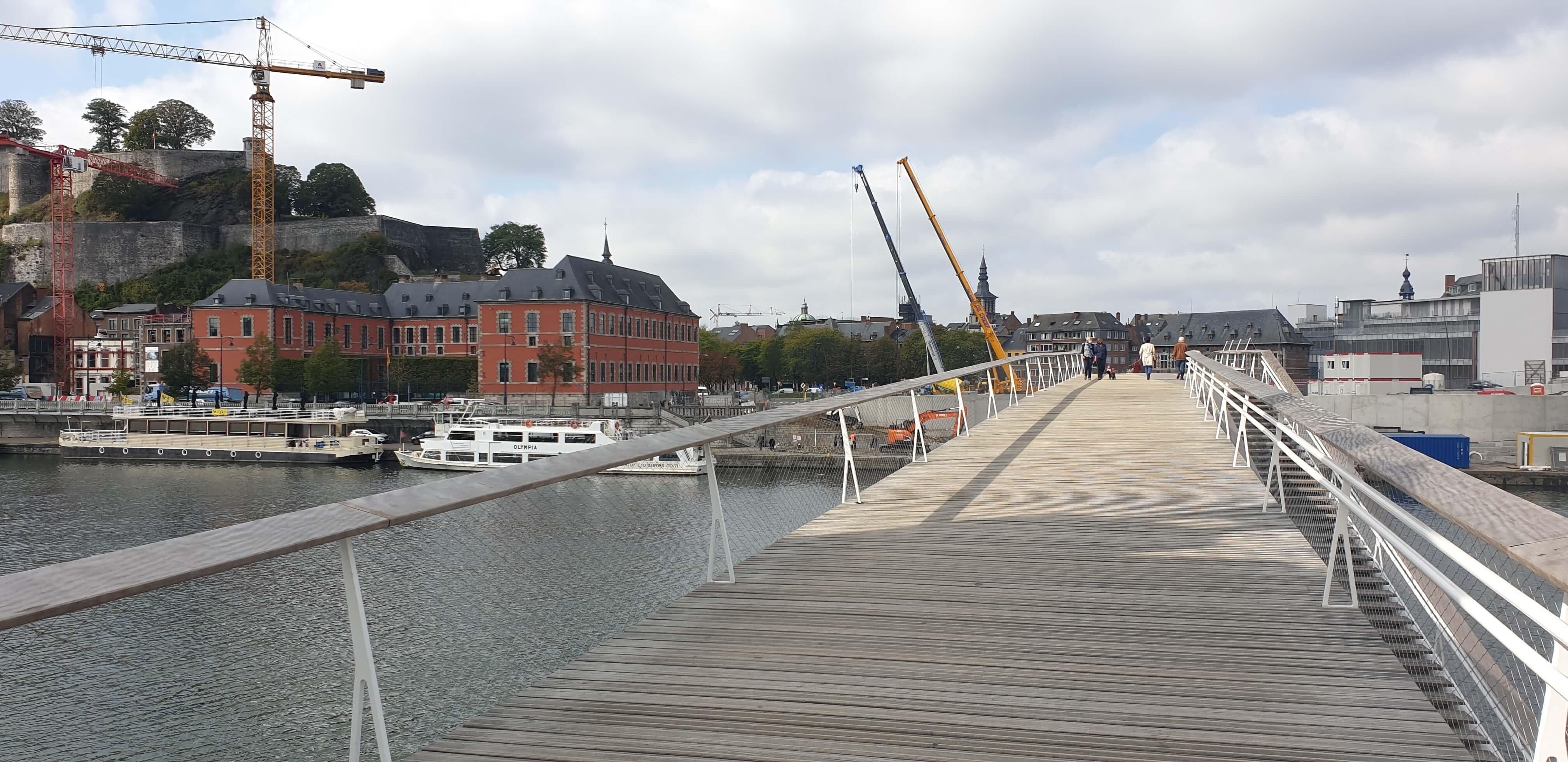 Houten voetgangersbrug met metalen leuning over het water in Namen